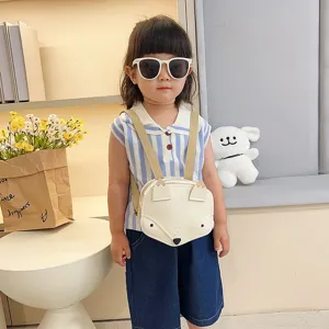 Detailed shot of the adorable cream-white fox-shaped backpack worn by a young child.