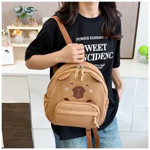 Nahaufnahme des süßen braunen Bärenrucksacks mit gesticktem Gesicht an einem Model.