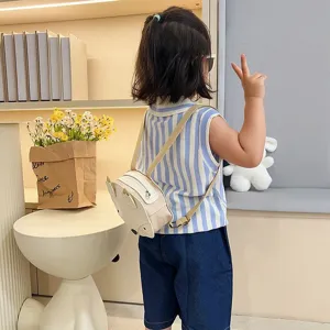 Back view of a child wearing a cute fox-shaped cream mini backpack in a cozy room