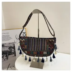 Etnische vintage hobo tas met kwastjes op een metalen standaard
