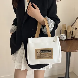 Minimalist white canvas handbag with brown straps shown in a lifestyle commuting scene