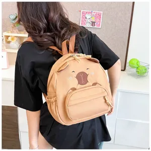 Detailansicht eines süßen braunen Bären-Rucksacks, getragen von einem Model im Zimmer.