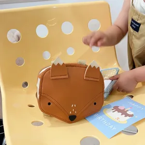 Adorable cartoon brown fox-shaped children's small backpack displayed on a yellow chair.