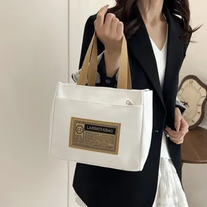 Minimalist Japanese style white canvas tote bag held by a model for daily commuting