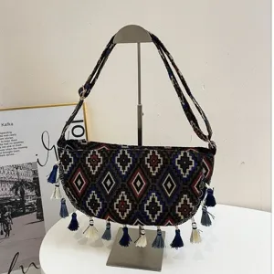 Detailweergave van etnische hobo-tas met kleurrijke kwastjes en geometrische patronen