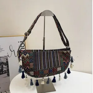 Detail van boho schoudertas met levendige geweven patronen en kwastjes.