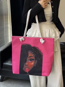 Vista detallada del bolso tipo tote rosa con estampado de chica negra y asas de cuerda