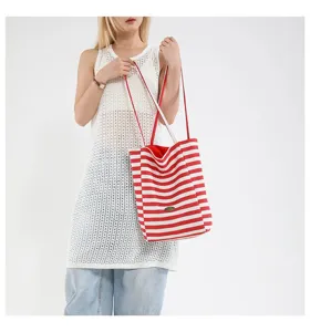 Bolso tote de lona a rayas rojas y blancas mostrado con modelo en un ambiente casual
