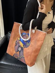 Vista detallada de un bolso tote con estampado de mujer africana y asas de cuerda.