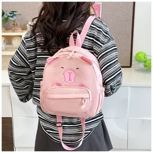 Detailansicht eines niedlichen rosa Rucksacks mit Tiermotiven, getragen von einem Modell