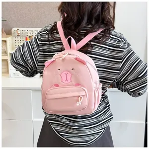 Rückansicht eines Mädchens mit einem süßen rosa Cartoon-Tierrucksack für Studentinnen