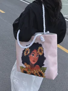 Detalle de bolso rosa con estampado de niña y girasoles y asas de cuerda gruesa.