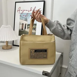 Detailed view of a minimalist Japanese style beige canvas tote bag held by hand