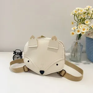 Cute cream fox-shaped children's backpack with adjustable straps on a white desk