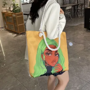 Vista detallada del bolso tote amarillo con estampado de chica negra y asa de cuerda.