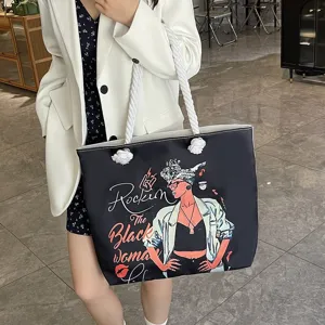 Vista detallada de un bolso tote negro con asa de cuerda y estampado gráfico de mujer