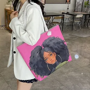 Detalle de bolso rosa con estampado de chica negra de dibujos animados y asas de cuerda