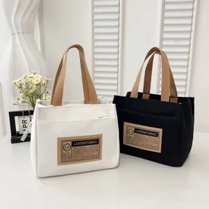 Minimalist canvas lunch tote bags in white and black colors with brown cotton handles.
