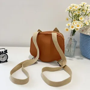 Rear view of orange children's fox-shaped backpack with beige canvas straps.