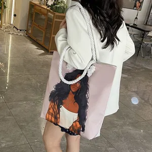 Mujer lleva un bolso tote rosa con estampado de chica negra y asas de cuerda