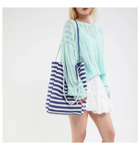 Bolso tote de lona a rayas azules y blancas con un conjunto informal de verano en modelo