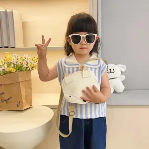 Cute fox-shaped children's backpack in cream leather worn by a young girl.
