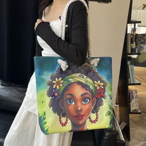 Detalle de un bolso tote con estampado de niña negra y correas de cuerda gruesa