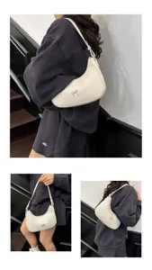 Elegante witte hobo-tas met zilveren strikdetail voor dagelijks gebruik door modieuze vrouwen.