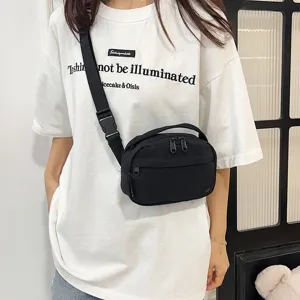 Una modelo mostrando el ajuste de un bolso bandolera minimalista de tela Oxford negra