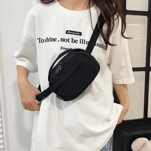 Detalle de una riñonera negra de tela Oxford impermeable sobre una camiseta blanca.