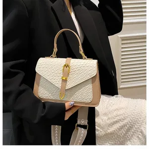 Vista detallada de un elegante bolso bandolera de textura tejida con correa ancha de moda