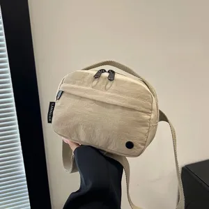 Vista de detalle de un bolso bandolera de tela Oxford impermeable beige