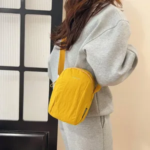 Detalle de bolso bandolera de nailon amarillo impermeable para un estilo informal