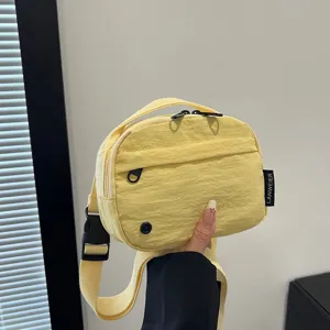 Primer plano que muestra la textura de un bolso compacto amarillo de tela Oxford impermeable