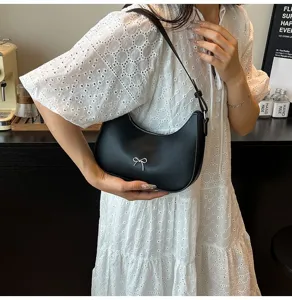 Elegante zwarte schoudertas met een zilveren strikje op glad kunstleer.