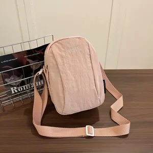 Detalle que muestra tela de nailon rosa impermeable y correa de hombro ajustable