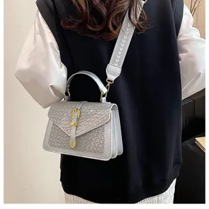Bolso bandolera cuadrado plateado tejido mostrado en una modelo con correa ancha