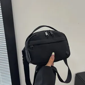 Vista detallada de un bolso bandolera ligero de tela oxford negra impermeable mujer.