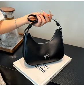 Elegante zwarte hobo-tas in de vorm van een halve maan met een zilveren strik.