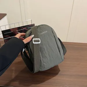Detalle de cerca del bolso bandolera ligero de nailon verde oliva con bordado LANWEIER