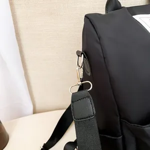 Detailopname van de metalen gesp en versterkte stiksels op een zwarte rugzak