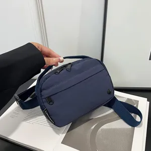 Vista detallada de la bandolera oxford impermeable azul marino con etiqueta de logotipo
