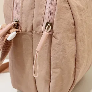 Primer plano de las cremalleras y el tejido de nailon impermeable del bolso rosa