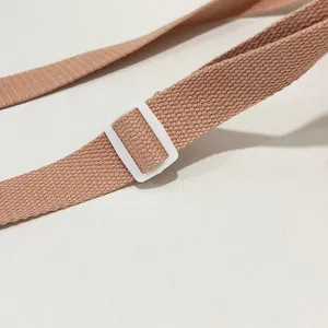 Detalle de cerca de la correa ajustable de nailon rosa y la hebilla de un bolso para móvil