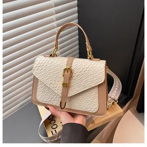 Primer plano detallado del patrón tejido y hebilla dorada en un elegante bolso beige