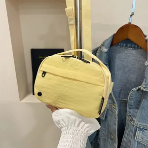 Primer plano de la textura de un bolso bandolera amarillo de tela Oxford impermeable