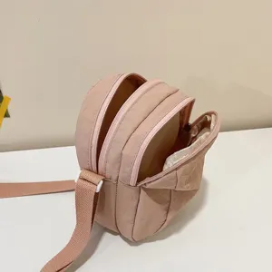 Detalle de los tres compartimentos con cremallera del bolso bandolera de nailon ligero.