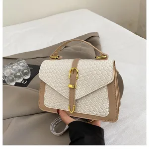Elegante bolso bandolera beige de textura tejida con detalles dorados y asa para mujer.