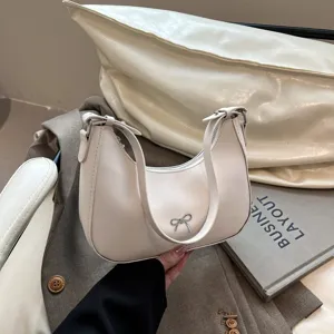 Close-up van gebroken witte zadeltas met zilveren strik