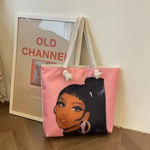 Detalle del bolso tote rosa con un estampado de chica negra y asa de cuerda blanca